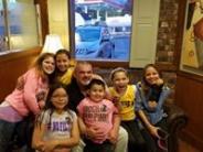 Children posing with a police officer at a local restaurant 