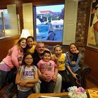 Children posing with a police officer at a local restaurant 