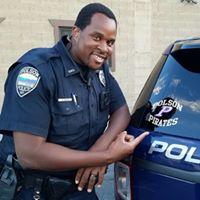 police officer pointing to a new decal on police vehicles that says "Polson Pirates" which is the local school mascot