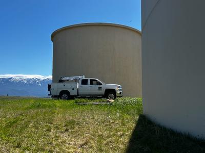City truck by water reservoir with Missions in the background